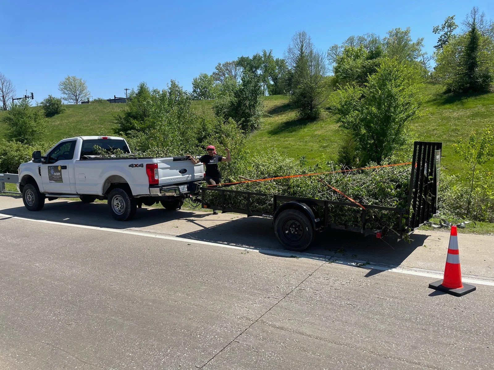 Ivory Commercial truck and loaded vegetation trailer at a fieldwork site